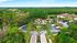 Aerial view of a luxurious apartment complex surrounded by lush greenery and serene water features, providing a tranquil and inviting atmosphere.
