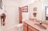 Elegant bathroom with granite countertop, stylish shower, and warm decor for a cozy ambiance.