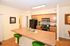 Modern apartment kitchen with granite countertops, sleek black appliances, and stylish wooden cabinetry.