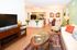 Charming open-concept living room and kitchen area with vibrant decor, modern furnishings, and sleek hardwood floors, perfect for a cozy and stylish lifestyle.