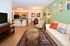 Bright and inviting living space with modern decor, cozy seating, and an open kitchen with stylish bar stools.