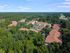 Charming residential community nestled in lush greenery with red-tiled roofs, offering serene and picturesque surroundings.