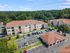 Charming apartment complex surrounded by lush greenery, featuring modern architecture, spacious parking, and a serene environment.
