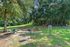 Charming outdoor playground featuring swings, a colorful climbing dome, and a picnic area nestled among lush greenery, ideal for family enjoyment.