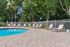 Inviting outdoor pool area with sun loungers and lush greenery, perfect for relaxation and leisure.