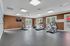 Bright and modern gym room featuring state-of-the-art exercise equipment, large windows, and inviting natural light.