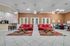 Inviting communal space with vibrant red sofas, stylish bar area, and elegant lighting; ideal for relaxation and social gatherings.