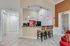 Modern apartment interior with a stylish breakfast bar, elegant pendant lighting, and cozy seating area, perfect for social gatherings.