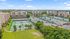 Vibrant residential community featuring modern high-rise apartments surrounded by lush greenery and multiple tennis courts, ideal for active lifestyles.