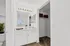 Bright and elegant bathroom with a sleek vanity and an inviting closet space, featuring abundant natural light through a stylish window.