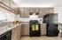 Modern kitchen with sleek wood cabinets, granite countertops, and stylish black appliances, offering a chic and functional space.