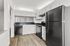 Modern kitchen with sleek black appliances, white cabinetry, and elegant wood flooring, perfect for culinary creativity.