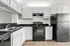 Modern kitchen with sleek black countertops, white cabinetry, and stainless steel appliances offering a stylish culinary space.