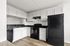 Modern kitchen with sleek black appliances, bright white cabinetry, and elegant countertops, perfect for gourmet cooking.