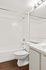 Bright and elegant bathroom featuring a pristine white bathtub, modern lighting, and sleek mirror creating a stylish and refreshing space.