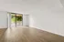 Bright and spacious living area with elegant hardwood floors and large sliding glass doors leading to a charming balcony.