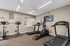 Modern apartment gym equipped with treadmills, exercise bikes, and a TV for entertainment, perfect for a convenient workout.