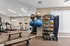 Modern fitness center featuring a variety of exercise equipment including treadmills, exercise balls, and weights under bright lighting.