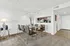 Bright and inviting dining area with a modern glass table, elegant chairs, and stylish lighting, seamlessly connected to a contemporary kitchen.
