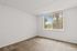 Bright room with large sunny window and lush green view, perfect for creating a personalized oasis.