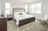 Elegant bedroom featuring a plush bed with stylish headboard, accented by modern nightstands and abundant natural light from large windows.