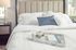 Elegant bedroom setting with a plush bed, stylish pillows, and a marble tray holding a cup and book, exuding a cozy and inviting ambiance.