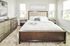 Luxurious bedroom featuring a plush king-size bed with elegant bedding, modern dresser, and soft natural light from large windows.