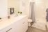 Elegant bathroom featuring a modern vanity with ample storage, chic decor, and a pristine shower area creating a serene retreat.