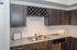 Modern kitchen with sleek gray cabinetry, granite countertops, and a convenient wine rack, offering an elegant and functional space.