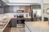 Modern kitchen with sleek dark wood cabinets, stainless steel appliances, and stylish granite countertops.