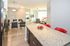Modern open-concept apartment showcasing a sleek kitchen island, elegant dining area, and cozy living room with abundant natural light.