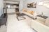 Modern living room with stylish decor, plush sofas, and open-concept kitchen featuring sleek appliances and elegant lighting.