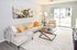 Bright and inviting living room with plush beige furnishings, modern decor, and large glass sliding doors offering natural light and outdoor views.
