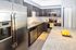 Modern kitchen with stainless steel appliances, granite countertops, and stylish dark wood cabinets featuring a built-in wine rack.
