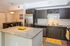 Modern kitchen with granite countertops, stainless steel appliances, and stylish cabinetry, featuring bright citrus-themed decor.