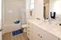 Bright and playful bathroom featuring a chic vanity with elegant fixtures, a cozy bathtub, and lively shark-themed decor for a splash of fun.