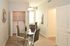 Modern apartment dining area with glass table, sleek chairs, and built-in laundry. Bright and inviting for stylish living.
