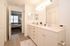 Elegant bathroom design featuring a double vanity with sleek faucets and ambient lighting leading into a cozy bedroom.