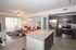Contemporary open-concept living space featuring a sleek kitchen with stainless steel appliances, elegant living room with modern decor, and vibrant pops of red for a stylish touch.