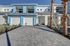 Modern duplex with sleek design, featuring vibrant blue accents and elegant palm trees in a sunny setting.