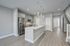 Modern kitchen with sleek stainless steel appliances, elegant pendant lighting, and a spacious white quartz countertop island.