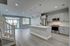 Contemporary open-concept kitchen and living area with sleek hardwood floors, modern appliances, and ample natural light.