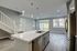 Modern open-concept living area featuring a sleek kitchen island, elegant pendant lighting, and large windows for natural light.