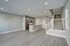 Modern open-concept living space with sleek kitchen, stainless steel appliances, and elegant staircase.