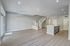 Modern open-concept living area with sleek flooring, elegant staircase, and a stylish kitchen island, perfect for entertaining.