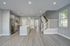 Modern open-concept kitchen and living area featuring sleek appliances, an elegant staircase, and ample natural light.