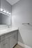 Modern bathroom with sleek white vanity, quartz countertop, and stylish lighting fixtures.