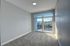 Bright and inviting bedroom featuring plush carpet, soft gray walls, and large sliding doors leading to a private balcony with serene views.