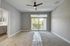 Bright and airy bedroom with modern ceiling fan, plush carpeting, and sliding glass doors leading to a serene balcony view.