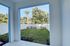 Charming view from a cozy patio overlooking a lush green backyard with tropical palm trees and a privacy fence.